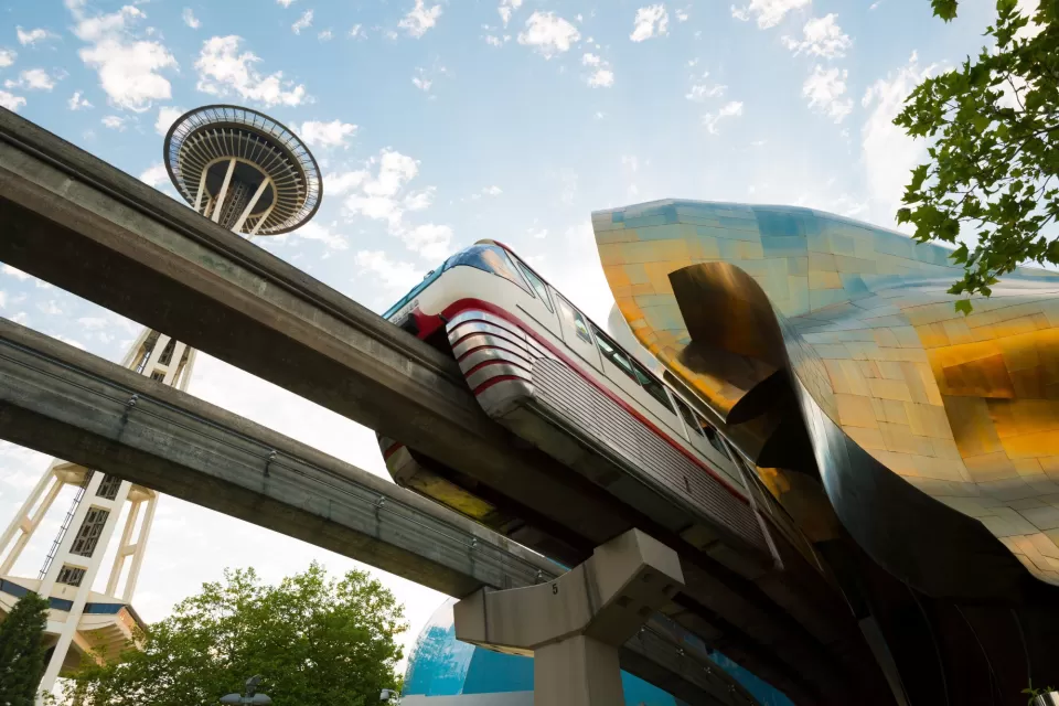 View from under track of Seattle monorail passing under Frank Gehry-designed Museum of Pop Culture with Space Needle in background